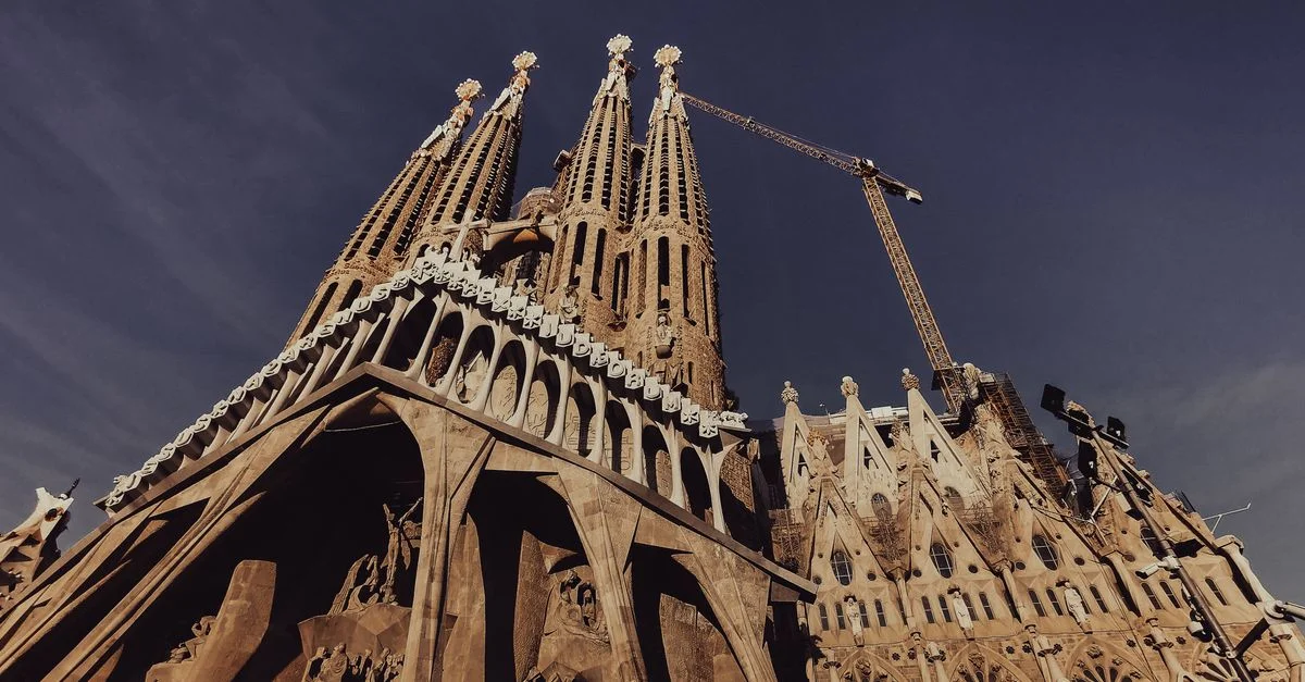 Impresionante toma en ángulo bajo de La Sagrada Familia en Barcelona bajo un cielo despejado.