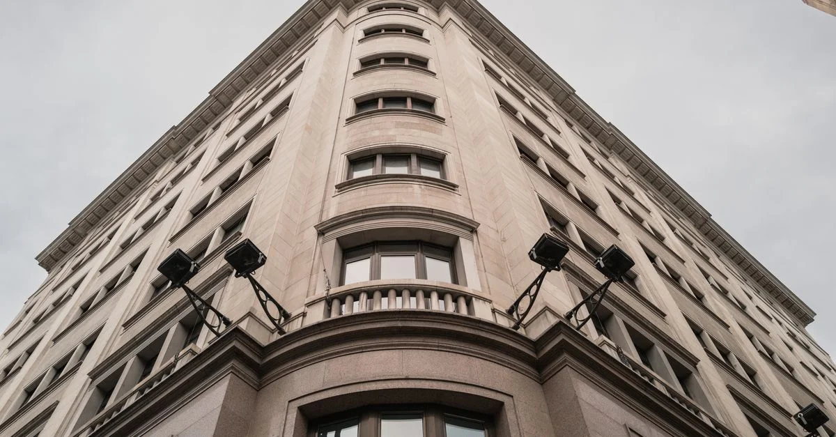 Vista en ángulo bajo de una fachada clásica de un edificio en Madrid, España, mostrando la arquitectura urbana.