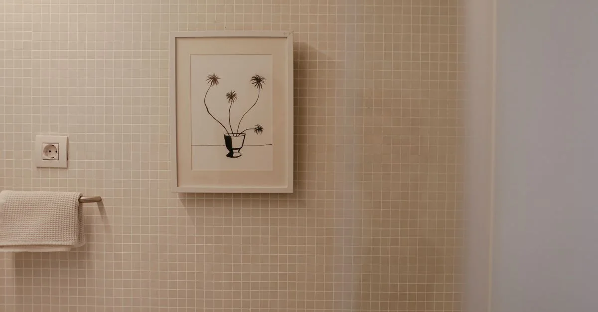 Un baño moderno que presenta una ilustración de planta enmarcada en la pared de azulejos, perfecta para inspiración de interiores.